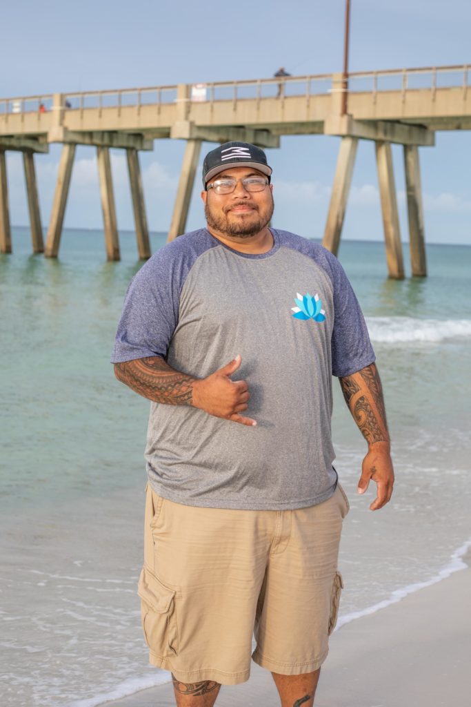 A happy man stands in water, his face beams with a broad smile