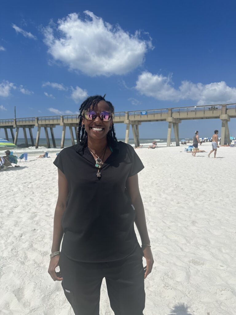 a woman with sunglass standing in the beach