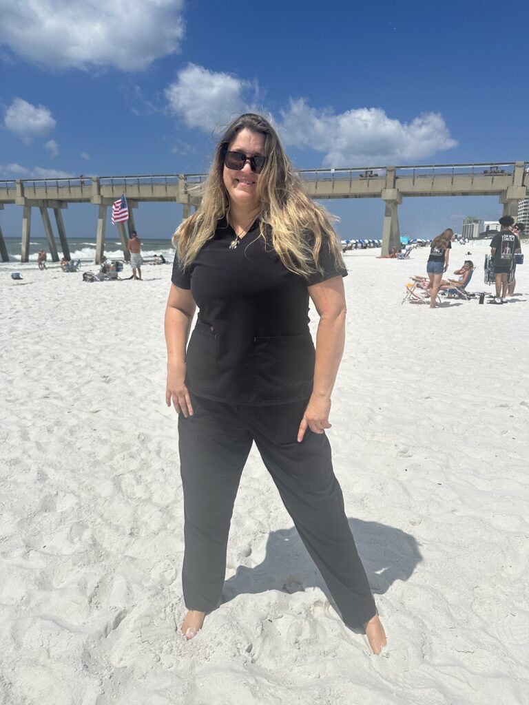 A woman in black dress standing in the beach